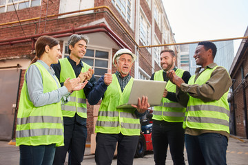 Erfolgreiches Logistik Team mit Laptop