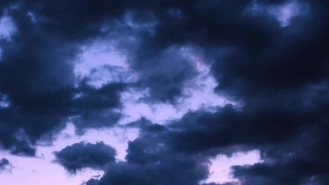Time-lapse Monsoon storm clouds gather in the Arizona skies at sunset turning the sky purple and pink.