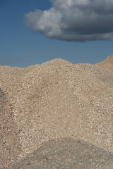 Mountains of sand and stone against a blue sky