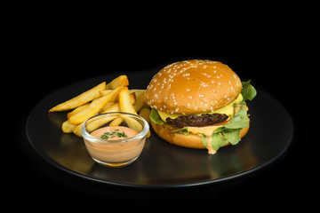 Beef Burger with french fries and mayones sauce on black background