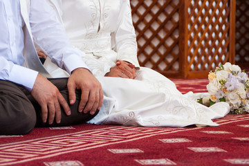 Muslim wedding rite. Bride and groom sitting on the floor in the moqsue. Muslim Wedding prayers. Nikah