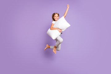 Full length photo of positive cheerful funny kid jump raise fist ahead imagine she strong superhero...