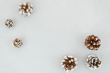 Christmas winter frame made of white pine cones decorated with snow paint on a white background. Flat lay, top view, copy space