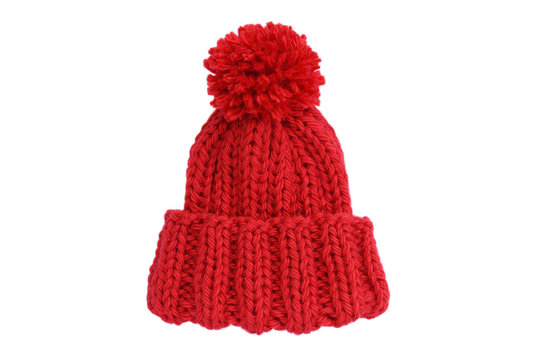 Small red knitted bobble hat isolated on a white background. Handmade woolly hat with pompom. Closeup. Copy space