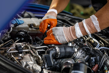 Fototapeta na wymiar Automobile mechanic repairing a car engine. man fixing the engine car. service and maintenance.