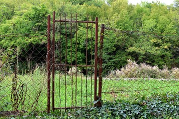 View of a farm gate leading into lush green countryside.