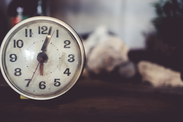 Selective focus of alarm clock with nature background.