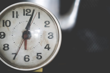 Selective focus of alarm clock with nature background.