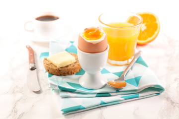 soft boiled egg with orange juice and coffee cup