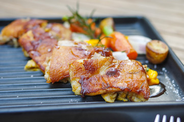 Roasted chicken with small baby carrots, potatoes, rosemary, garlic and mango sauce on black iron oven tray