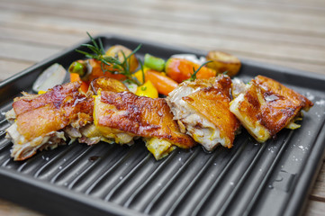 Roasted chicken meat slices with baby carrots, garlic, small potatoes, rosemary, sea salt and mango sauce on black nonstick oven tray