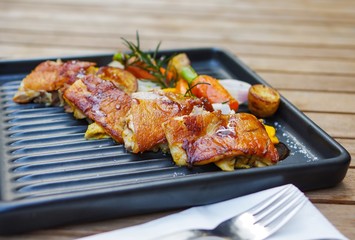 Roasted chicken with small baby carrots, potatoes, rosemary, garlic and mango sauce on black iron tray