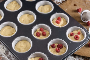 The process of making cupcakes, coating a cream from a pastry bag in the hands of a pastry chef.