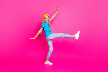 Fototapeta na wymiar Full size photo of cheerful positive funny funky girl raise her leg have fun on summer holidays feel candid wear shine sneakers clothes isolated over bright color background