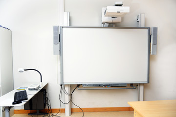 Interactive whiteboard with beamer as a modern school blackboard in the classroom, copy space - obrazy, fototapety, plakaty