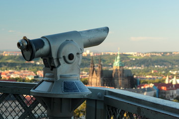 Telescope on Petrin Tower with the view of Prague Castle in the background. 