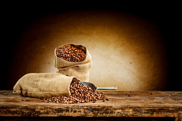 Fresh coffee in sacks and brown wooden desk of free space for your decoration with brown wall 