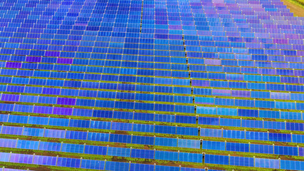 Ariel view , Shot from a drone on a farm field there are a lot of solar panels that produce...