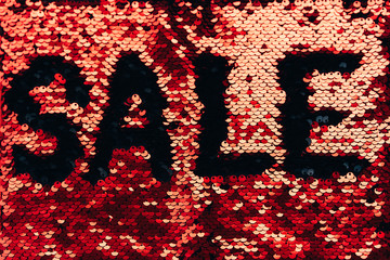 The inscription Sale made of red and black sequins. Festive concept of Christmas sales and discounts. Black Friday
