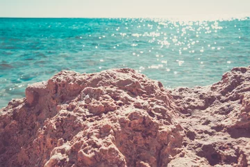 Fotobehang Bright sea summer landscape. The rocky coast against the azure sea with the edge lit by the sun. © Oleksandra