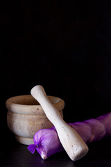 GARLIC IN NETWORK BAG ON WOOD MORTAR AND BLACK BACKGROUND 4. KITCHEN SPICE