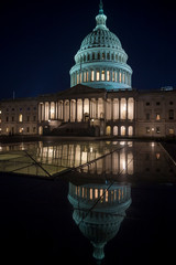 Fototapeta premium Scenic evening view of the glowing lights of the US Capitol Building with detail reflecting under night sky in Washington DC, USA