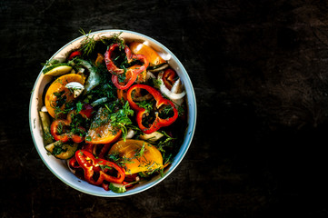 mixed salad in round bowl stays on dark shabby background