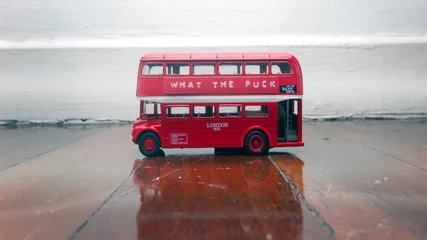 Rolgordijnen toy bus on a wooden floor with a message © charles taylor