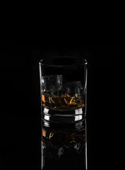 Whiskey with ice on a black background
