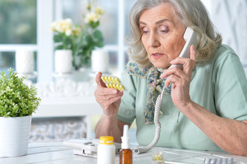 Portrait of sick senior woman sitting at table