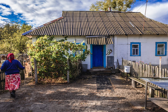 Self settler woman in front of her house in Kupovate village located in Chernobyl exclusion area, Ukraine