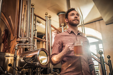 Fototapeta na wymiar Man tasting fresh beer in a brewery