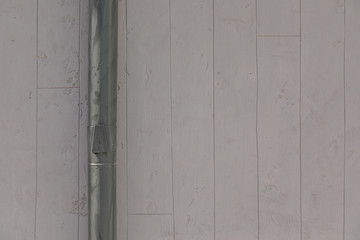 Close-up of grey striped concrete wall with metal rainwater downpipe