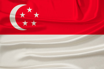 beautiful photograph of the national flag of Singapore on delicate shiny silk with soft draperies, the concept of state power, country life, horizontal, close-up, copy space