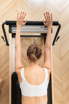 From above photo of a woman doing reformer pilates exercise.