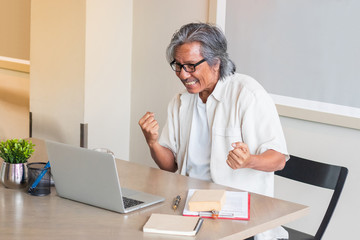 Senior man are working at home using computers and laptops, with the internet communicating online with other people.