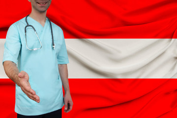 male doctor in uniform professional clothes with a stethoscope welcomes patients with his hand against the background of the national flag, the concept of the country's health and medical insurance