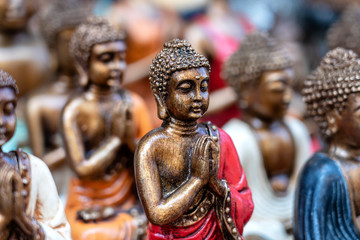 Buddha statue figures souvenir on display for sale on street market in Bali, Indonesia. Handicrafts and souvenir shop display, close up