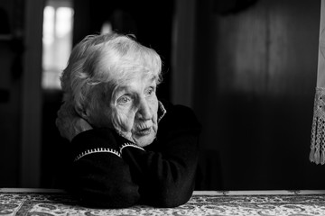 Black-and-white portrait of a sad old woman. Care for lonely pensioners.