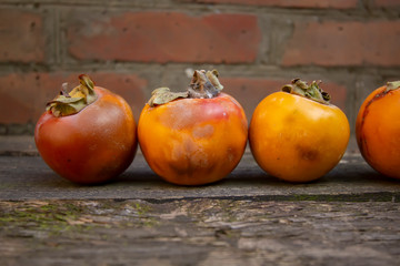 tasty ripe persimmons on a wooden table