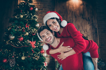 Close-up portrait of his he her she nice attractive cheerful excited glad kind careful spouses having fun spending December vacation in decorated lights loft industrial brick wood style interior
