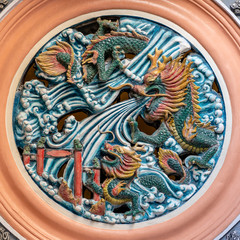 Detail of a dragon statue on a wall in a Chinese temple in Singapore, closeup