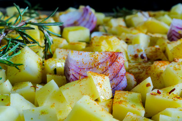 Primo piano di una teglia di patate, cipolle e aglio al forno, ricette e cucina