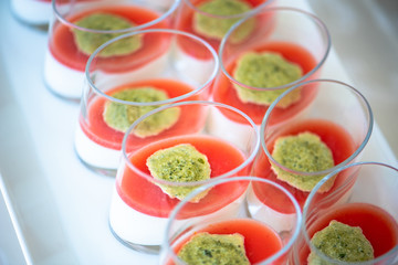 Vegetarian appetizer in a glass with cheese, tomato sauce and pesto