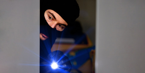 Einbrecher bei Einbruch mit Taschenlampe