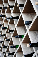 Bottles of wine on wooden shelves, street decor of a restaurant or bar.