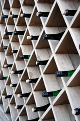 Bottles of wine on wooden shelves, street decor of a restaurant or bar.