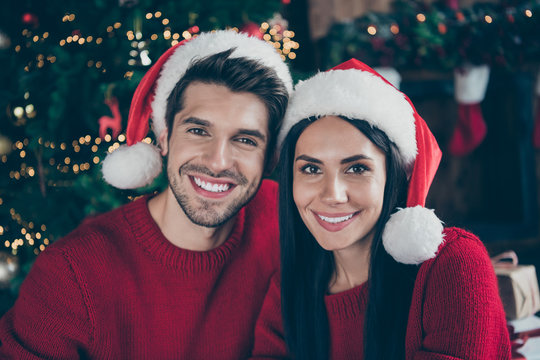 Close up photo of two romantic married people enjoying christmas celebrate x-mas holidays wearing newyear hat in house with noel decoration newyear lights indoors