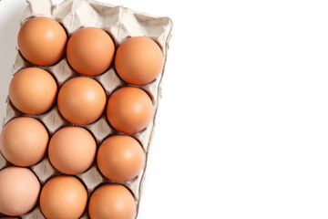 Chicken eggs in a cardboard box on white background. Organic Food.Top view