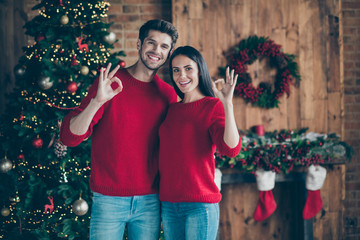 Portrait of two romantic couple showing ok sign enjoy christmas x-mas event standing indoors in...